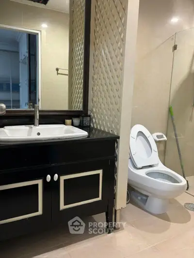 Modern bathroom with sleek black vanity and glass shower enclosure