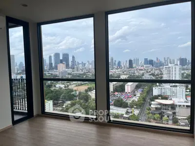 Stunning cityscape view from high-rise apartment with floor-to-ceiling windows.