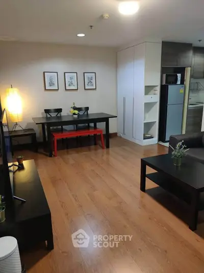 Spacious living room with modern furniture and wooden flooring in a stylish apartment.