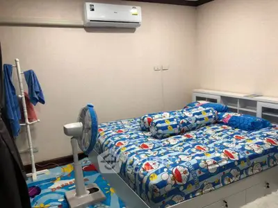 Cozy bedroom with colorful bedding and air conditioning unit, perfect for comfortable living.