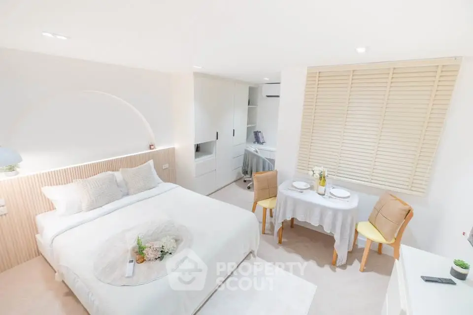 Bright and cozy bedroom with dining area, modern decor, and ample storage space.