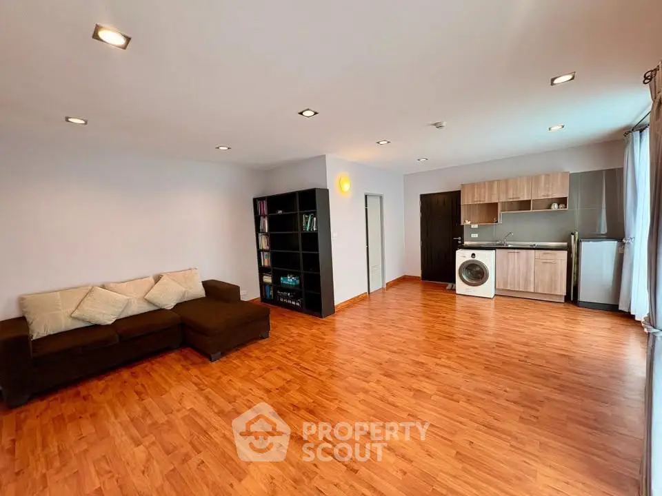 Spacious open-plan living room with modern kitchen and hardwood floors