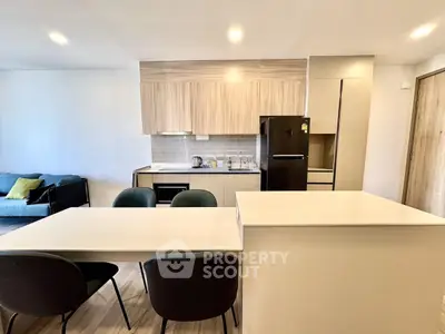 Modern open-plan kitchen and living area with sleek design and contemporary furniture.