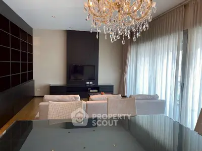 Luxurious living room with elegant chandelier and modern furnishings in a spacious apartment.