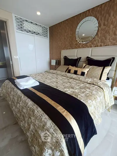 Luxurious bedroom with elegant decor and plush bedding in modern apartment.