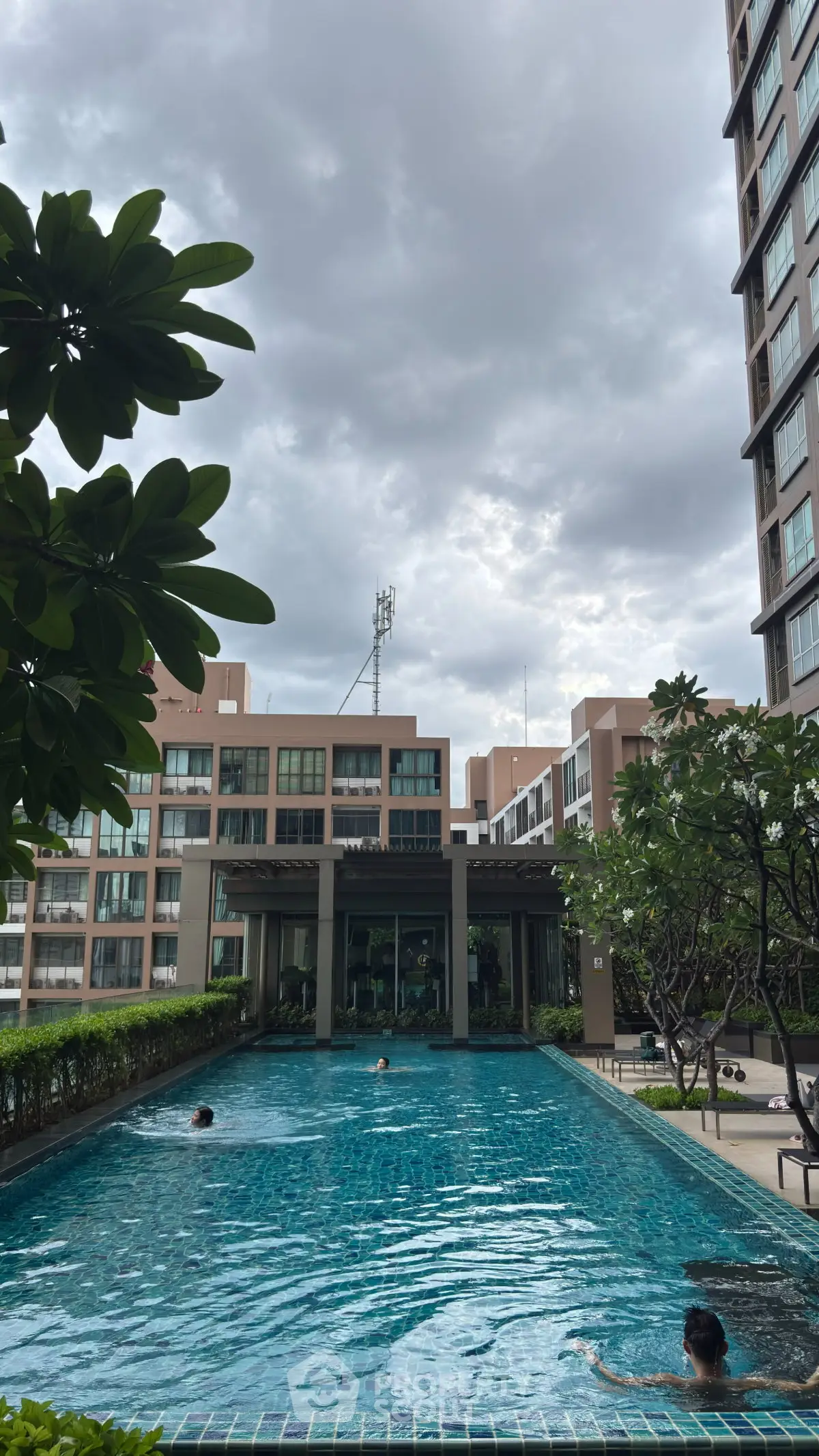 Luxurious residential complex with a stunning outdoor pool and lush greenery, perfect for relaxation and leisure.