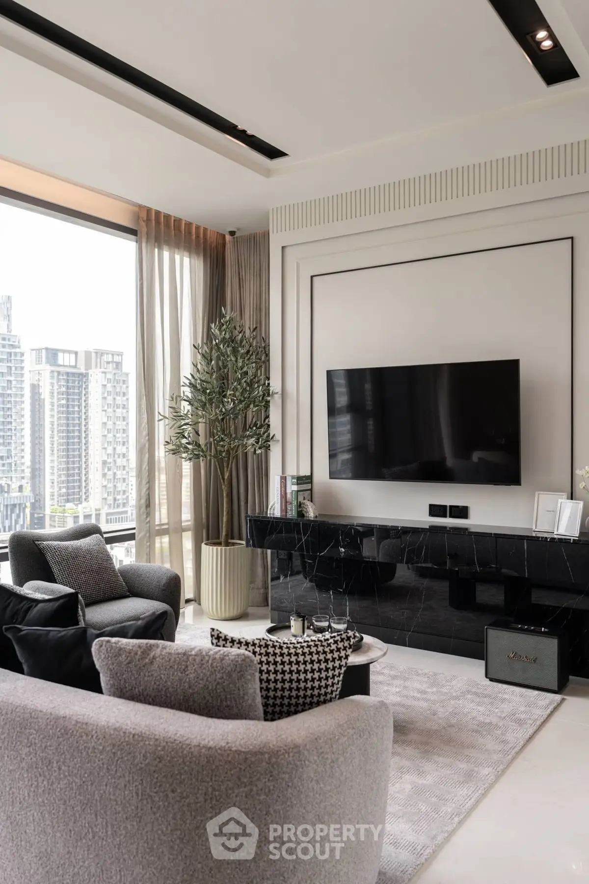 Luxurious modern living room with city view, featuring sleek TV setup and elegant decor.