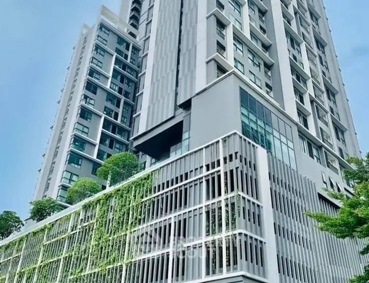 Modern high-rise building with lush vertical garden and sleek architectural design.