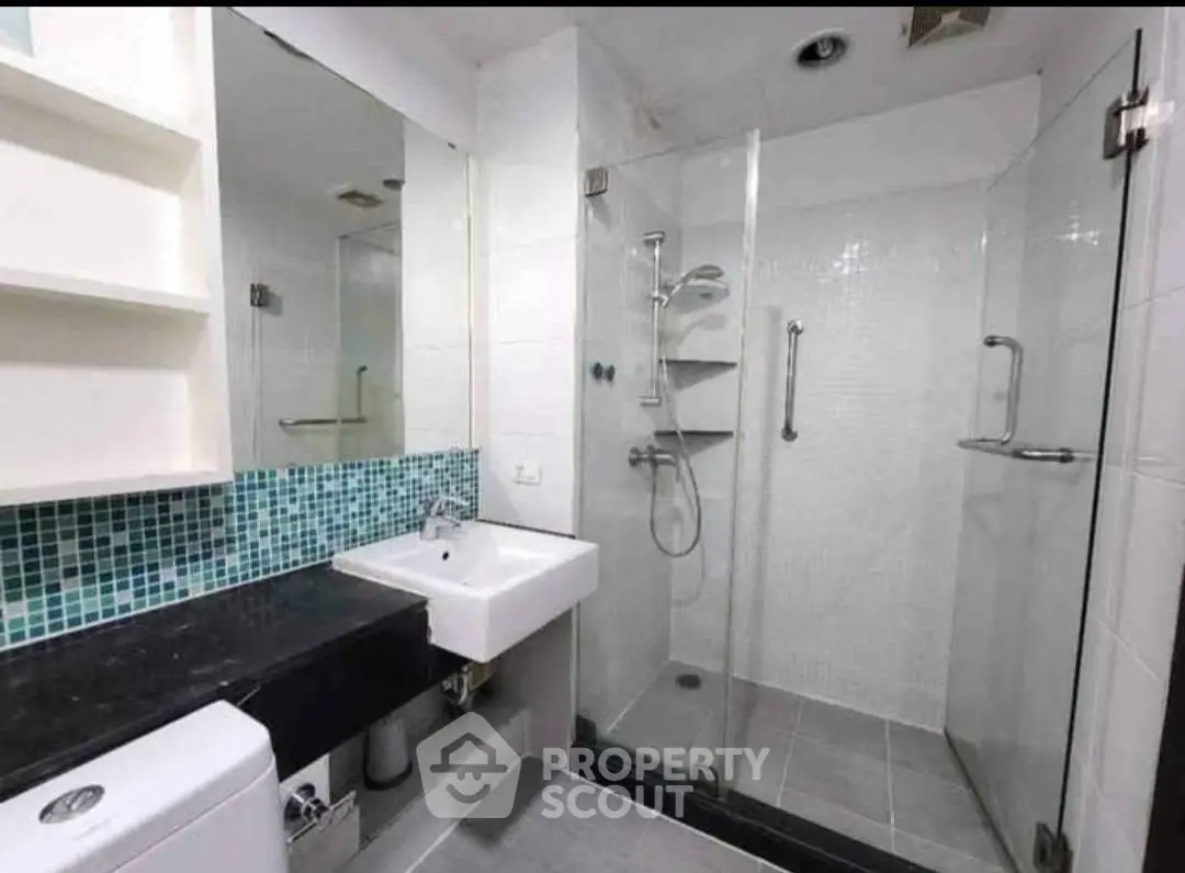 Modern bathroom with glass shower enclosure and stylish tile accents.