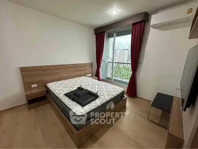 Modern bedroom with large window and city view, featuring a comfortable bed and sleek furnishings.