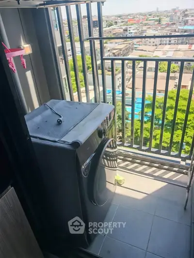 Compact balcony with city view and washing machine, ideal for urban living.