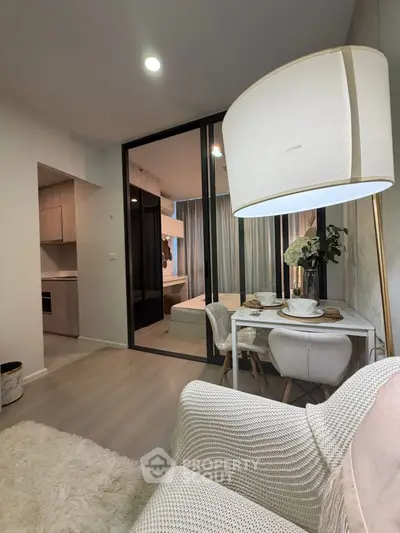 Modern living room with cozy seating and elegant dining area in open layout apartment.