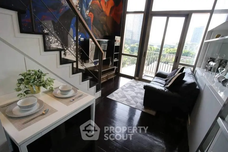 Modern loft with stylish decor, large windows, and city view, featuring a cozy living area and dining space.
