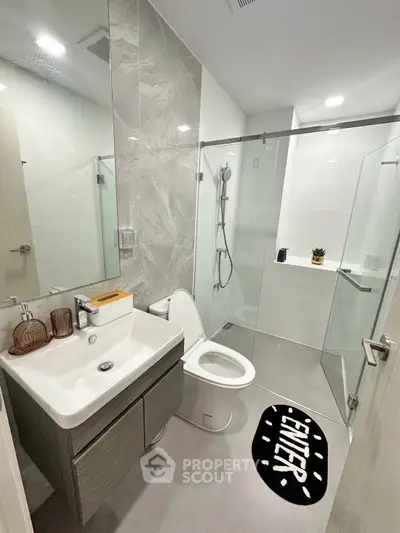 Modern bathroom with sleek design, glass shower, and stylish fixtures in a contemporary apartment.
