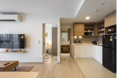 Modern open-layout living room and kitchen with sleek design and cozy ambiance.