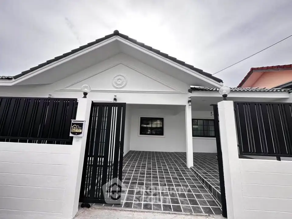 Charming single-story home with gated entrance and modern exterior design.