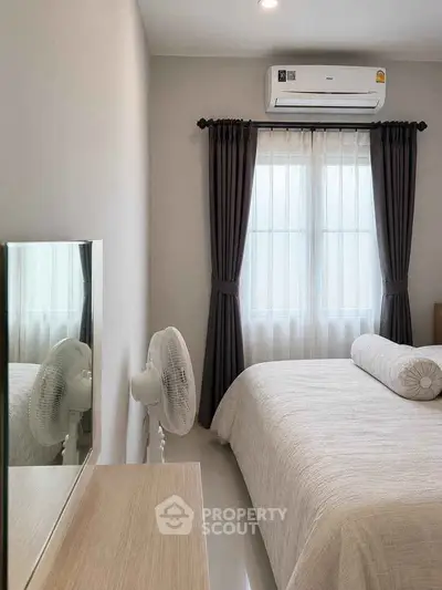Cozy bedroom with air conditioning and elegant curtains, perfect for relaxation.