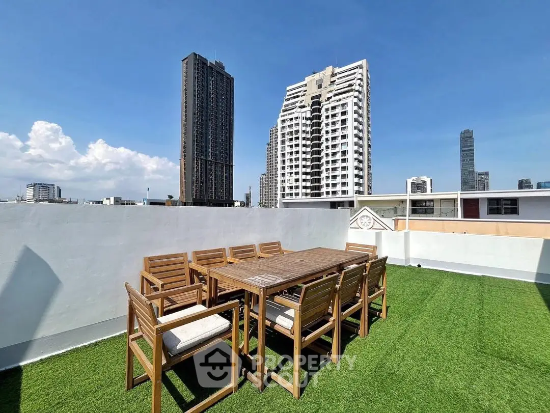 Stunning rooftop terrace with city skyline views and outdoor dining set.