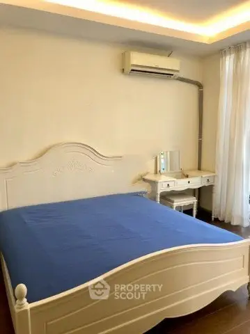 Spacious bedroom with elegant white furniture and air conditioning