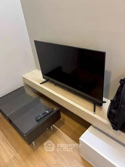 Modern living room with sleek TV setup and stylish furniture.