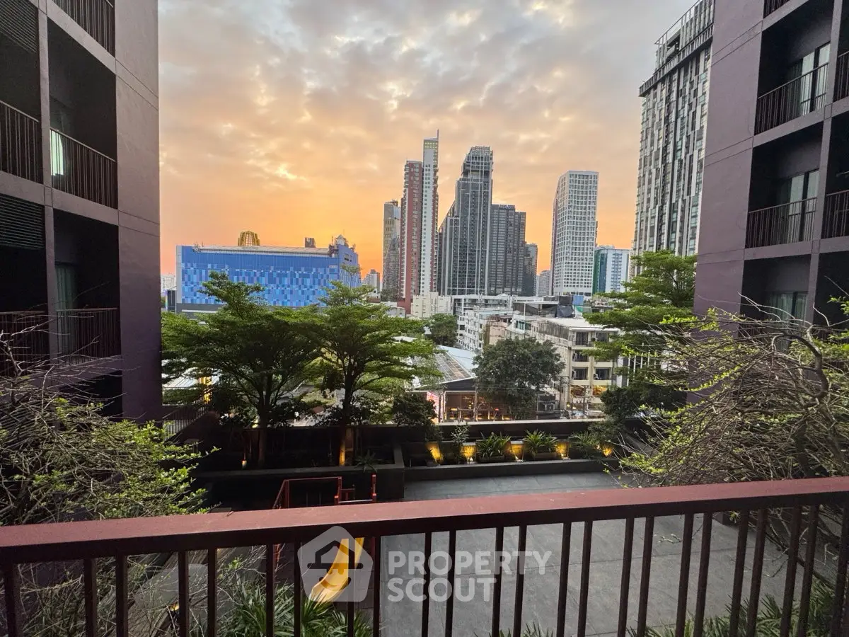 Stunning cityscape view from a modern balcony at sunset, showcasing urban living with lush greenery.