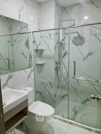 Modern bathroom with marble tiles and glass shower enclosure