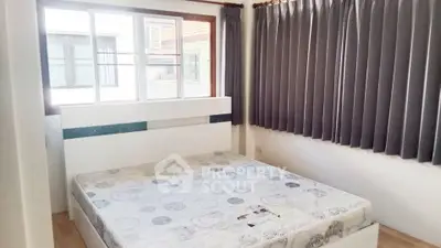 Bright bedroom with large window and modern design in a cozy apartment.