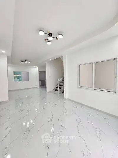 Spacious modern interior with marble flooring and elegant lighting, perfect for stylish living.