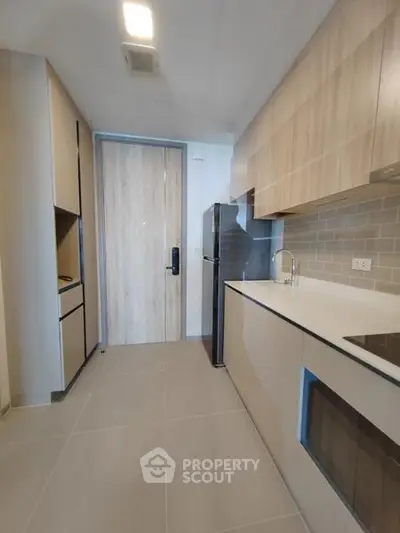 Modern kitchen with sleek cabinetry and integrated appliances in a contemporary apartment.