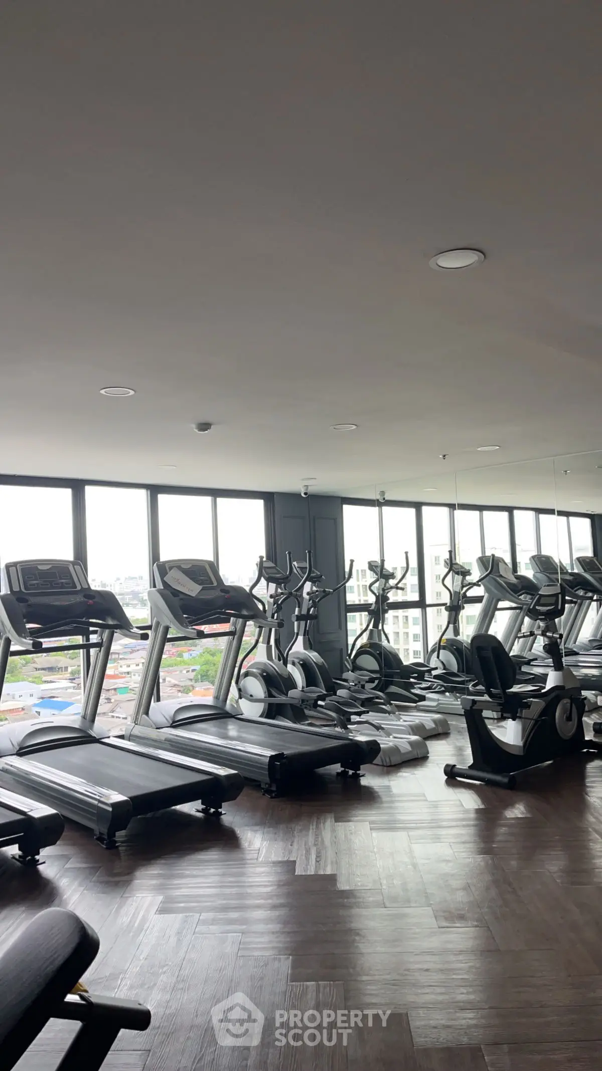 Spacious modern gym with city view and state-of-the-art equipment.