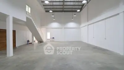 Spacious industrial-style open space with high ceilings and mezzanine.
