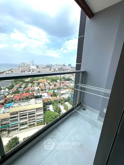 Stunning high-rise balcony with panoramic city and ocean views, perfect for urban living.