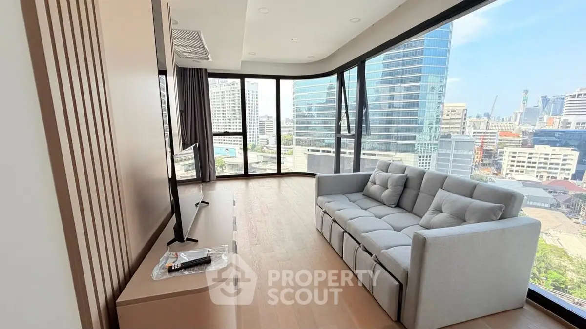 Modern living room with panoramic city view and sleek furniture in high-rise apartment.