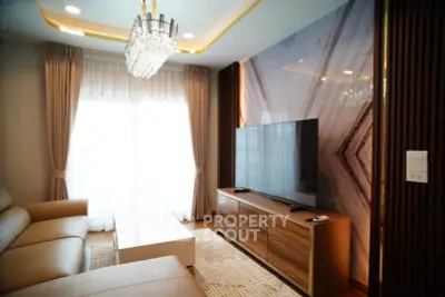 Luxurious living room with elegant chandelier and modern TV setup