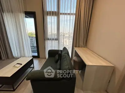 Modern living room with high ceilings and large windows offering city views.