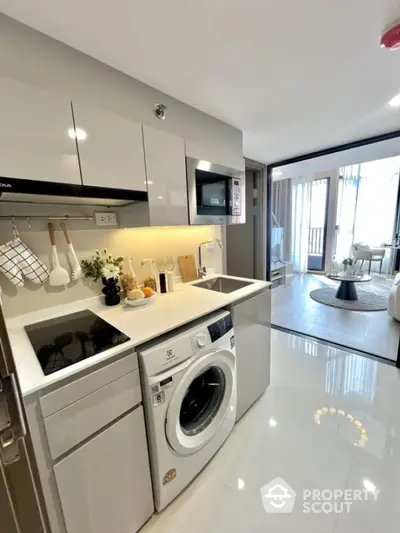 Modern kitchen with sleek appliances and open layout leading to stylish living room