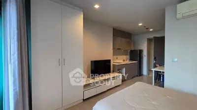 Modern studio apartment with sleek design and compact kitchen area