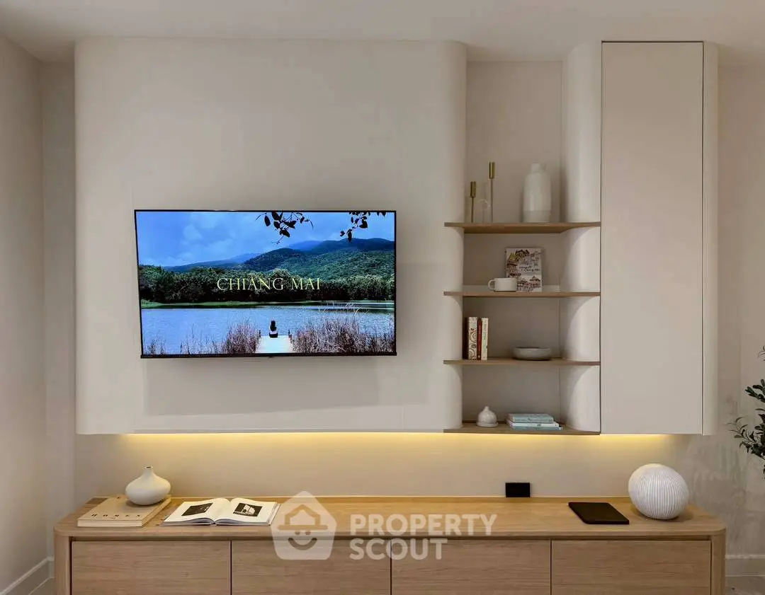 Modern living room with wall-mounted TV and stylish shelving in a cozy setting.