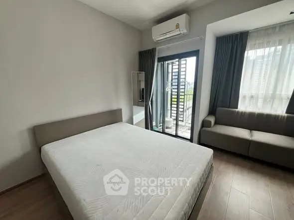 Spacious bedroom with balcony access in modern apartment