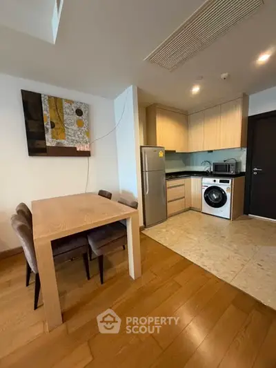 Modern kitchen with dining area, featuring sleek appliances and stylish decor.