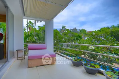 Spacious balcony with lush garden view and cozy seating area.