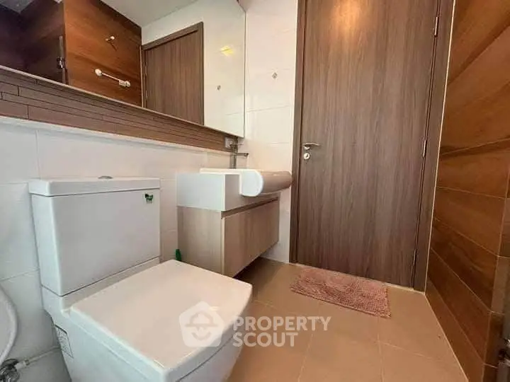 Modern bathroom with sleek fixtures and wooden accents, perfect for a contemporary home.