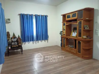 Spacious living room with wooden flooring and elegant blue curtains