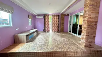 Spacious living room with vibrant purple walls and stylish tile flooring
