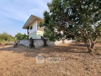 Charming rural two-story house with spacious yard and lush trees, perfect for serene living.