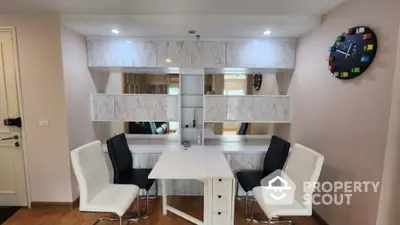 Modern dining area with stylish chairs and wall-mounted clock in a cozy apartment