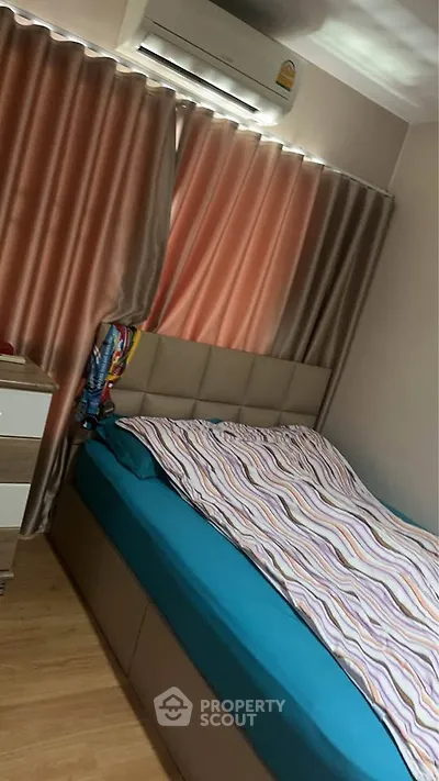 Cozy bedroom with modern decor and air conditioning, featuring a comfortable bed and stylish curtains.