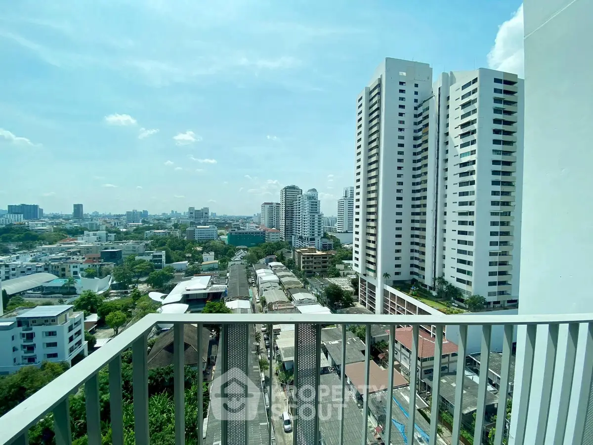 Stunning cityscape view from a high-rise balcony with modern buildings and clear skies.