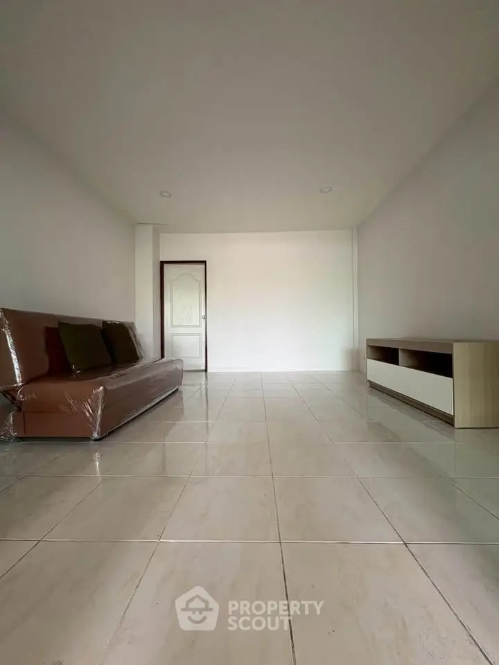 Spacious minimalist living room with tiled flooring and modern furniture