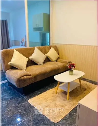 Cozy living room with plush sofa and stylish coffee table in modern apartment.